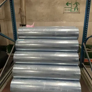 Clear lamination embossing film rolls with a distinctive blue protective tint in factory storage, displaying high-volume wholesale capacity